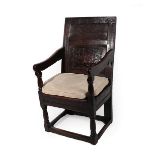 A 17th Century Joined Oak Wainscot Armchair, the back support with moulded stiles above two carved