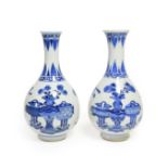A Pair of Chinese Porcelain Bottle Vases, Kangxi, painted in underglaze blue with scrolls and