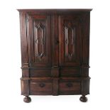 An Oak Cupboard, the moulded canopy above fielded cupboard doors enclosing later hooks and pegs,