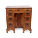 A Walnut and Oyster Veneered Kneehole Dressing Table, in George I style, the crossbanded moulded top