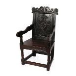 A 17th Century Joined Oak Wainscot Armchair, later initialled PM and dated 1725, the carved top in