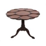 A Carved Mahogany Tripod Table, the circular dished and carved flip-top on a stop-fluted column