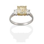 A Diamond Three Stone Ring, the central fancy light yellow modified square brilliant cut diamond, in