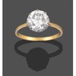 A Diamond Solitaire Ring, the round brilliant cut diamond in a white claw setting, to a yellow