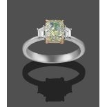 A Diamond Three Stone Ring, the central fancy light greenish-yellow cushion modified brilliant cut