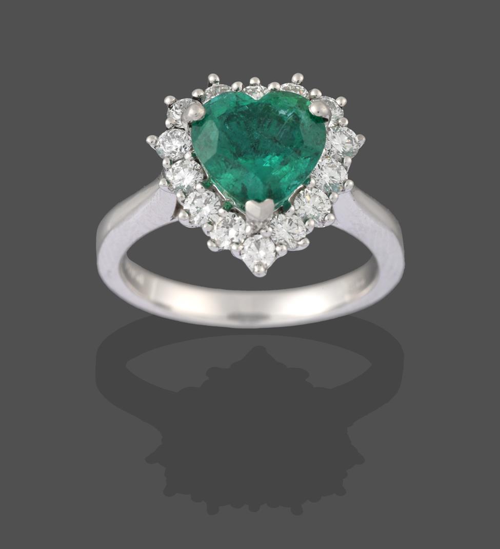 A Platinum Emerald and Diamond Cluster Ring, the heart shaped emerald within a border of round