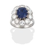 An 18 Carat White Gold Sapphire and Diamond Cluster Ring, the oval cut sapphire within a border of