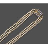 A Three Row Pearl Necklace, the graduated 99:89:96 pearls strung to a square clasp with a hairwork