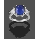 A Sapphire and Diamond Three Stone Ring, the cushion cut sapphire flanked by two trilliant cut