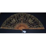 A Large Late 19th Century Wood Fan, the pale tan monture elaborately carved with exotic flowers