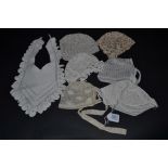 A Selection of Baby or Doll Bonnets and a Crochet Bib, the latter most probably 19th century French.