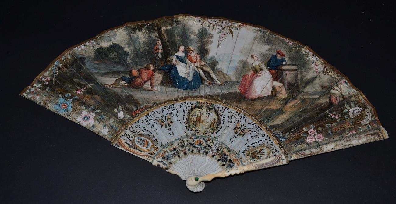 An 18th Century Ivory Fan, the slender monture carved, pierced and painted in colour, the gorge with