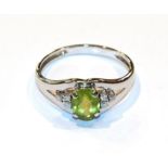 A peridot and diamond ring, finger size Z1/2. Indistinctly marked. Gross weight 4.9 grams.