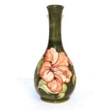 A Walter Moorcroft bottle vase, coral hibiscus pattern on green, 26cm high. Minor surface