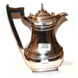 A George V silver hot-water jug, Retailed by Harrods, Sheffield, 1934, baluster and on four ball