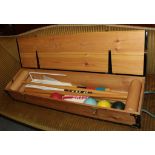 A modern croquet set in a pine case, containing four croquet mallets, four balls, fours hoops .