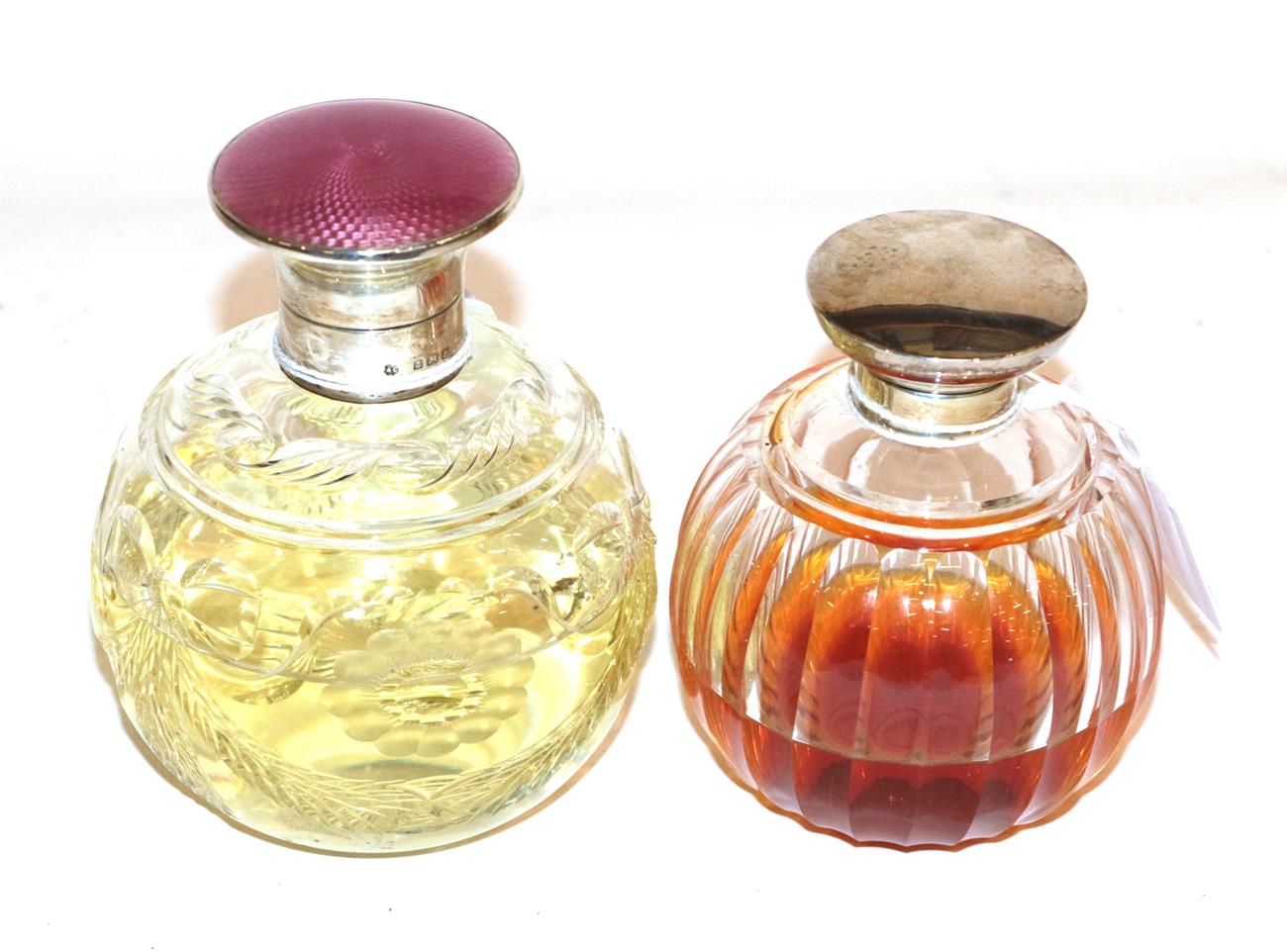 Two silver topped cut glass scent bottles, the first Albert Carter, Birmingham, 1926, the body