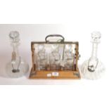 Three decanters in Tantalus with silver sherry spirit, various dates and makers together with a pair