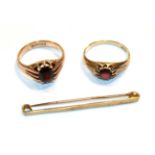 Two 9 carat gold garnet rings, finger sizes R and S and a 9 carat gold bar brooch . Larger garnet