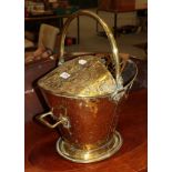 A Victorian brass coal scuttle, 47cm high with swing handle together with a pair of brass candle