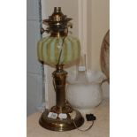 A Victorian oil lamp, opaque shade, iridescent striped glass reservoir, gilt brass base. Minor chips