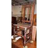 An 18th century Provincial oak chair, with a scroll carved crest rail, plank seat, on turned and