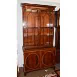 A Georgian style mahogany and satinwood banded bookcase, moulded cornice above twin glazed doors,