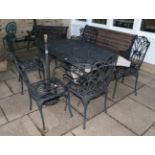 A metal garden table and set of six chairs with parasol