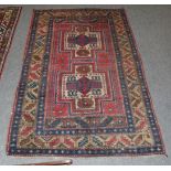 A Kazak Caucasian design rug, The terracotta field with two stepped medallions enclosed by leaf