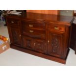 A reproduction bow-fronted sideboard with stained finish and carved panels, 157cm by 54cm by 94cm