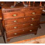 An early 19th century mahogany chest of two short over three long graduated drawers, oval gilt metal