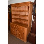 A 20th century pine dresser, moulded cornice above three shelves, base with two drawers above
