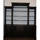 A 19th century oak bookcase, incorporating some earlier carved panels and pilasters, the upper