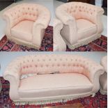 An Early 20th century Chesterfield three-piece suite upholstered in buttoned fabric, comprising a