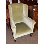 A Georgian style wingback armchair, green velveteen upholstery, mahogany square tapered legs to