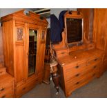 An early 20th century beech two piece bedroom suite comprising a mirrored fronted wardrobe, 121cm by