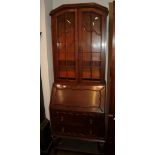 An Edwardian oak bureau bookcase, moulded cornice above twin glazed doors, the drum-top bureau