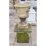 An impressive weathered composition garden canpana urn, on a heavily weathered stone plinth