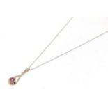 A pink sapphire and diamond pendant on chain, the round cut pink sapphire and round brilliant cut