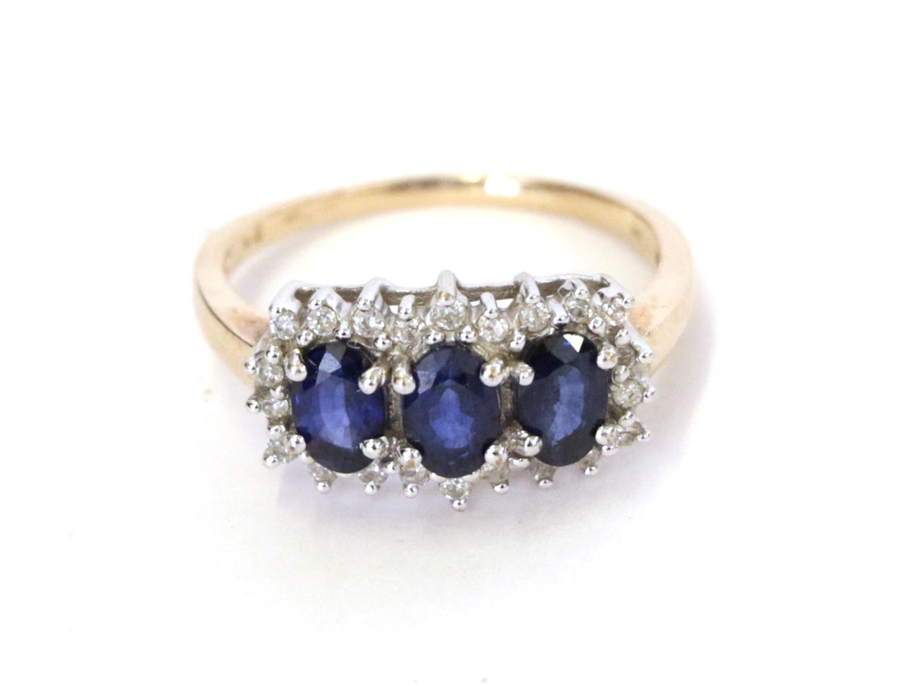 A 9 carat gold sapphire and diamond cluster ring, three oval sapphires within a border of eight-