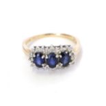 A 9 carat gold sapphire and diamond cluster ring, three oval sapphires within a border of eight-