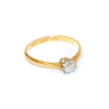 A diamond solitaire ring, the round brilliant cut diamond in a white claw setting, to a yellow