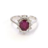 A synthetic ruby and diamond cluster ring, the oval cut synthetic sapphire within a border of