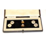 A pair of mother-of-pearl cufflinks and two dress studs, of button design, cased NB: Two studs