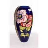 A large Walter Moorcroft clematis pattern vase, on a blue ground, signed and impressed factory