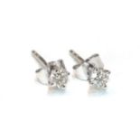 A pair of 18 carat white gold diamond solitaire earrings, the round brilliant cut diamonds in four