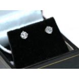 A pair of diamond solitaire earrings, the round brilliant cut diamonds in white four claw