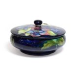 A Walter Moorcroft Clematis pattern powder bowl and cover, on a blue ground, impressed factory