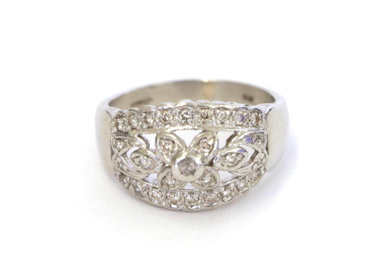 A platinum diamond ring, the central floral cluster flanked by tapered bars set throughout with