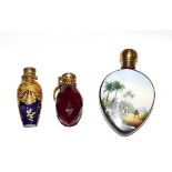 Three brass-mounted scent-bottles, one porcelain, painted with exotic landscapes, one gilt decorated